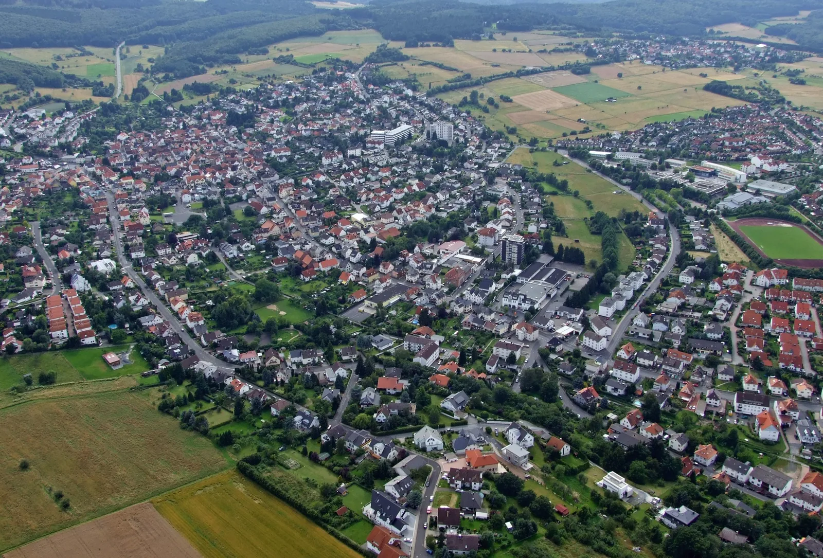 Luftbild von Neu-Anspach mit Wohnstraßen, Ortskern und Feldern am Rand